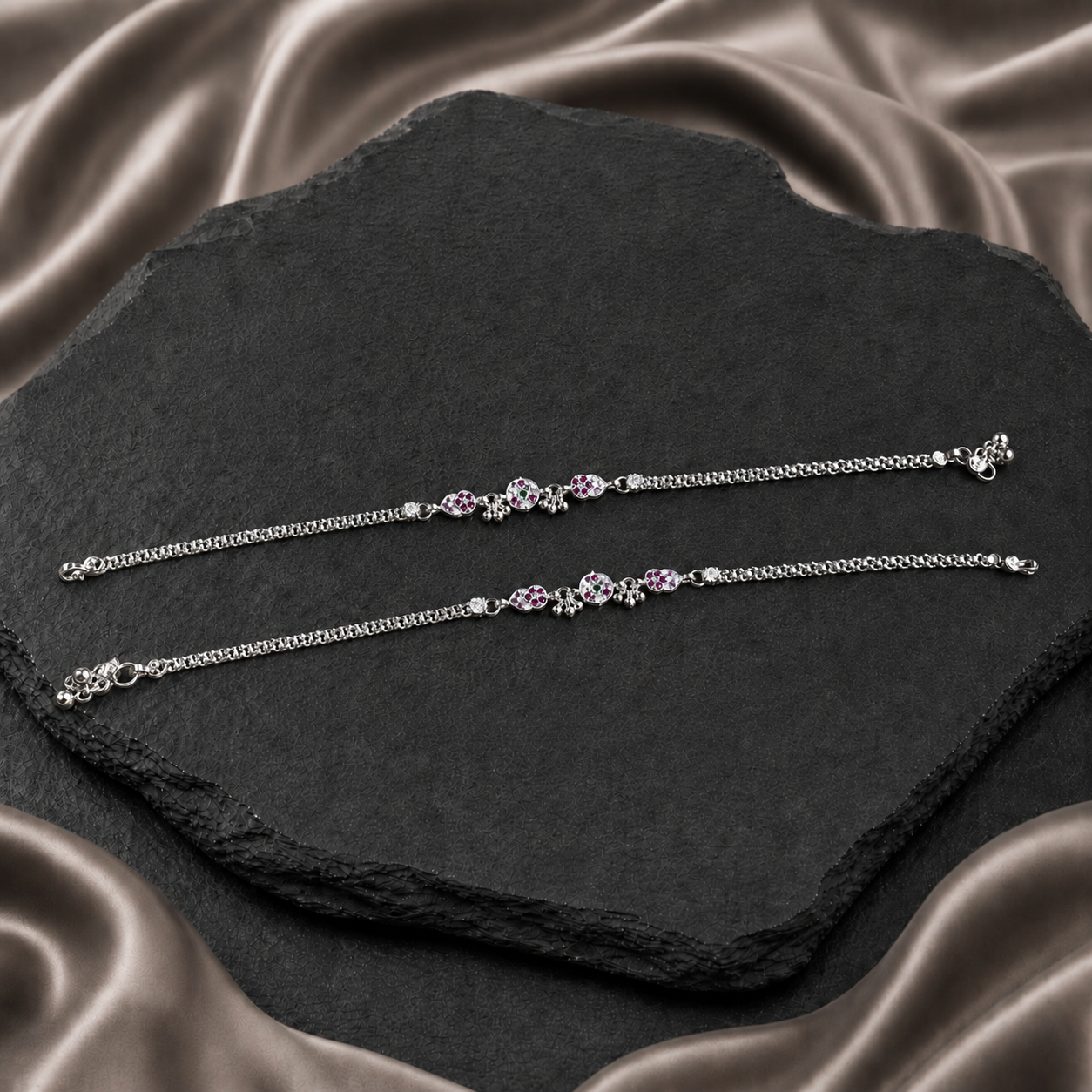 Pair of silver chain payals with pink paisley details and bell charms